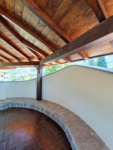 a patio under a wooden roof with a brick floor at Villa Sarchi in Grantola