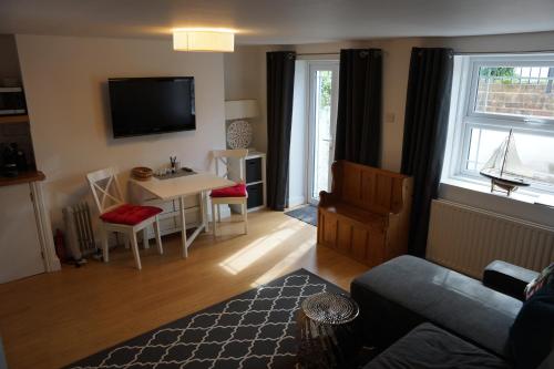 a living room with a couch and a table at Stunning pied-a-terre moments from the water. in Netley