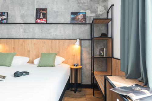 a hotel room with two beds and a shelf at ibis Lyon Sud Oullins in Oullins