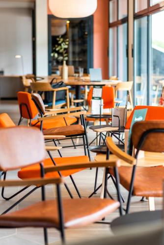 an empty cafeteria with chairs and tables and windows at ibis Lyon Sud Oullins in Oullins