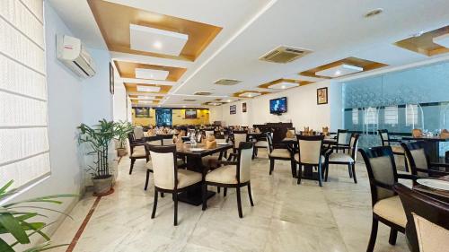 een eetkamer met tafels en stoelen in een restaurant bij Surasena Regal Vista Agra in Agra