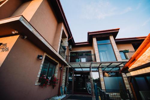 un edificio de apartamentos con puerta y balcón en Pensiunea Bello en Marghita