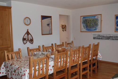 uma sala de jantar com mesa e cadeiras e um relógio em Résid. Les Esserts B40 em Champoussin