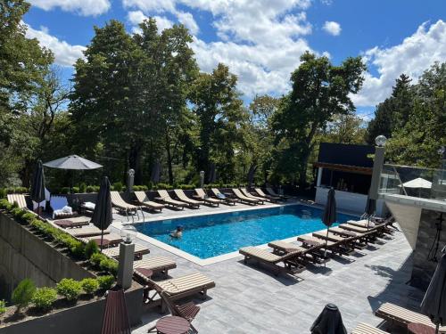 una piscina con tumbonas y un montón de plantas en The Residence Hotel & Cottages, en Kojori