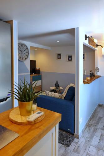 a living room with a blue couch and a clock at La Bulle Bleue Futuroscope in Chasseneuil-du-Poitou