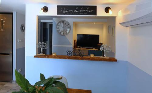 a living room with a tv and a clock on the wall at La Bulle Bleue Futuroscope in Chasseneuil-du-Poitou