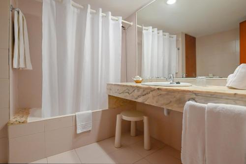 a bathroom with a sink and a tub and a shower at O7 Club Cala Ratjada in Cala Ratjada