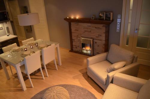 a living room with a table and a fireplace at Castillo Kelotähti Apartment in Saariselka