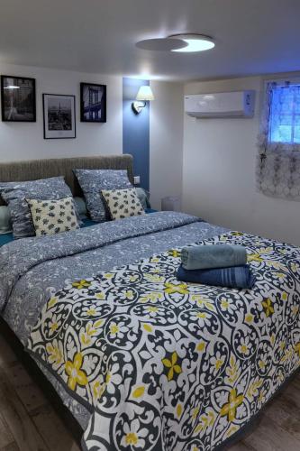 a bedroom with a bed with a blue and yellow blanket at La Bulle Bleue Futuroscope in Chasseneuil-du-Poitou