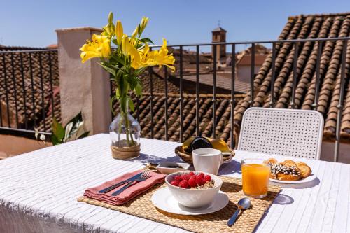 einen Tisch mit einem Teller Essen und einer Vase Blumen in der Unterkunft La Casa De Almocita in Dúrcal