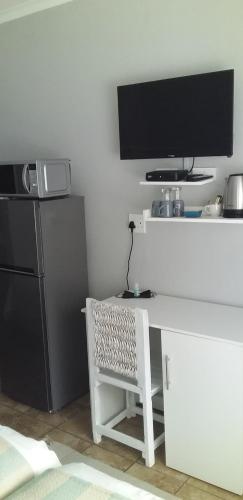 a white desk with a television and a refrigerator at B&B 464 on 22nd Ave in Pretoria