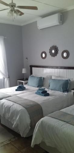 a bedroom with two large beds with blue pillows at B&B 464 on 22nd Ave in Pretoria