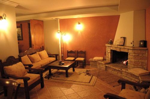 a living room with a couch and a fireplace at Aroanios Hotel in Klitoria