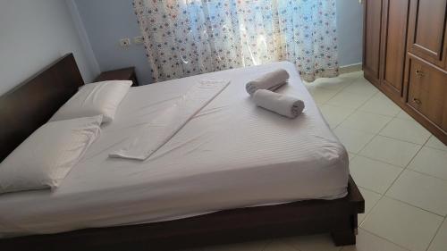 a bed with white sheets and two pillows on it at Charming Apartment Lushnje in Lushnjë