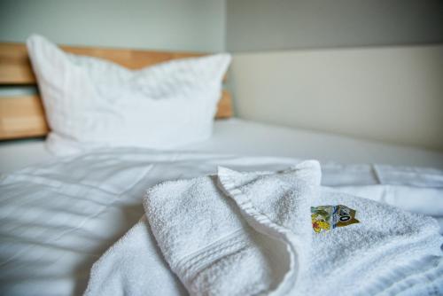 a bed with white towels on top of it at Hotel City Inn in Magdeburg