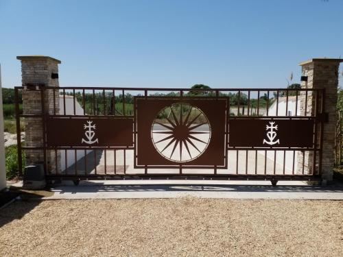 une porte avec une roue au-dessus dans l'établissement Domaine du Soleil Couchant, à Saintes-Maries-de-la-Mer