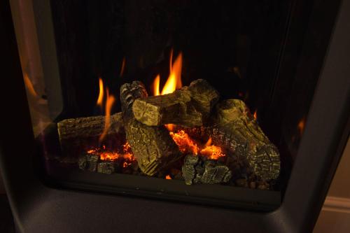 a fireplace filled with lots of fire in it at Little Fox Lodge Luxury Hideaway with Hot Tub Glencoe Near Fortwilliam in Glencoe