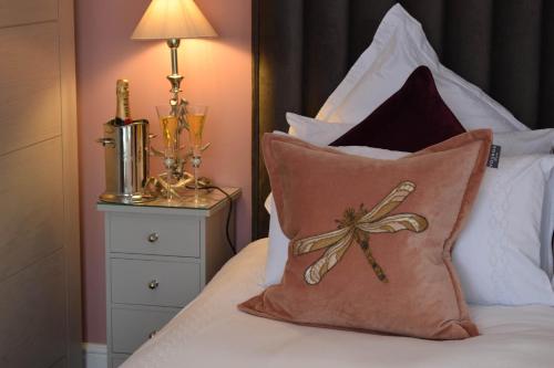 a bed with a pillow with a bow on it at Little Fox Lodge Luxury Hideaway with Hot Tub Glencoe Near Fortwilliam in Glencoe