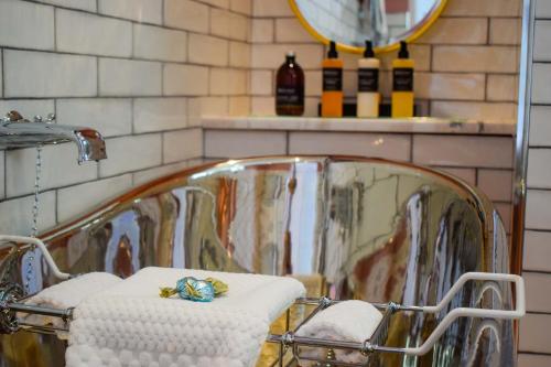 a bathroom with a mirror and two towels and a sink at Little Fox Lodge Luxury Hideaway with Hot Tub Glencoe Near Fortwilliam in Glencoe