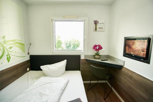 a small room with a bed and a window at Hotel City Inn in Magdeburg