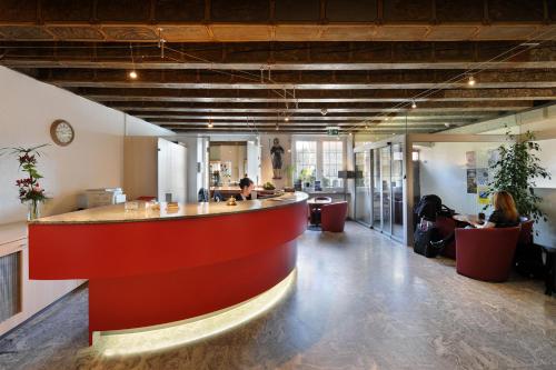 an office lobby with a red bar in the middle at Hôtel de la Rose in Fribourg