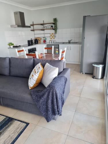 a living room with a couch and a kitchen at Alkion Villa in Wagga Wagga
