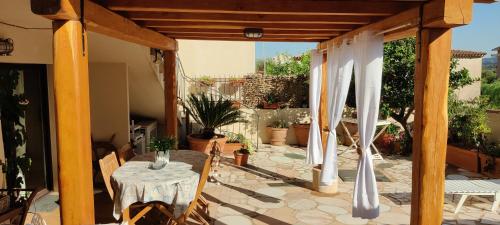 eine Terrasse mit einem Tisch und Stühlen auf einer Terrasse in der Unterkunft Casa massy in Arzachena