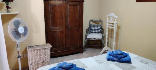 Zimmer mit einem Tisch, einem Ventilator und einem Schrank in der Unterkunft Casa massy in Arzachena