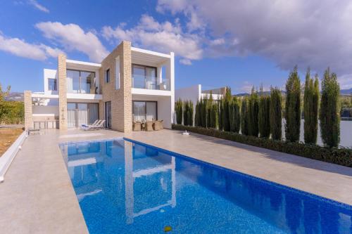 a villa with a swimming pool in front of a house at Coral Residences in Coral Bay