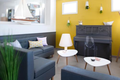 a living room with a couch and a fireplace at Hotel Les Dunes in La Tranche-sur-Mer
