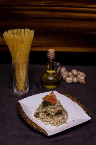 a plate of spaghetti and a bottle of oil at Hotel Mechi Crown, Jhapa in Kakarvitta