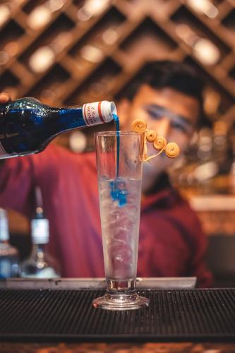 a bottle is being poured into a drink at Hotel Mechi Crown, Jhapa in Kakarvitta