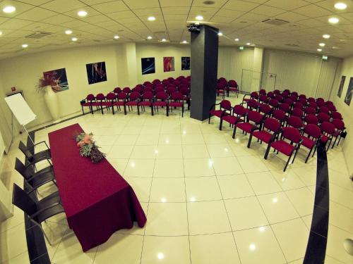 a banquet hall with red chairs and a table with flowers at Best Western Hotel Class Lamezia in Lamezia Terme