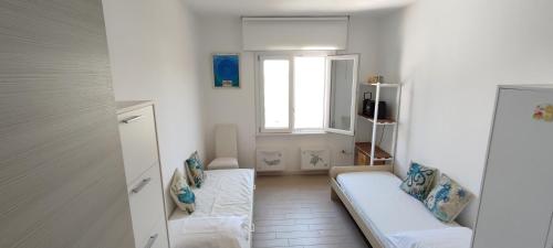 ein Wohnzimmer mit einem Sofa und einem Fenster in der Unterkunft Vistamare maddalena spiaggia in La Maddalena