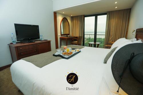 a hotel room with a bed with a tray of food on it at GRANADA l'Amitié in Bamako