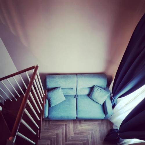 a blue couch in a room with a staircase at Palazzo Sarti Suites in Rodi Garganico