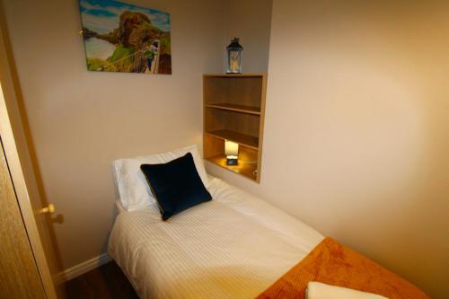 a small bedroom with a bed with a pillow on it at Beulah Guest House in Portrush