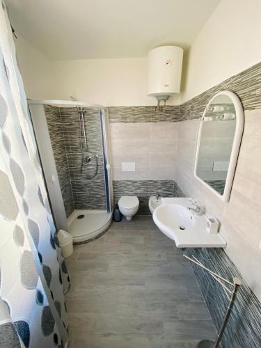 a bathroom with a sink and a shower and a toilet at Appartamento Orchidea in Parghelia