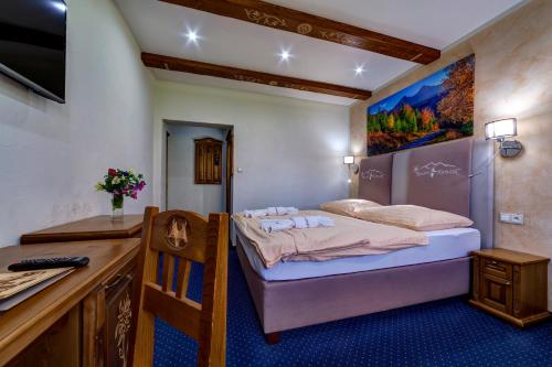 a small bedroom with a bed and a desk at Wellness Resort Kamzík in Ždiar
