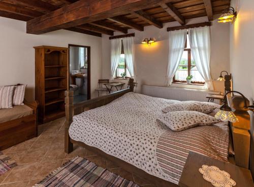 a bedroom with a bed and a table and windows at Matievics Bor&aacute;szat &eacute;s Vend&eacute;gh&aacute;z in Sz&aacute;lka