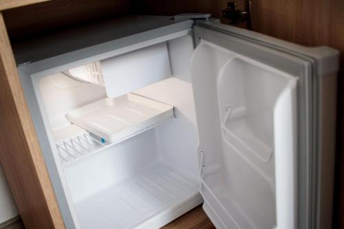 an empty white refrigerator with its door open at Agropensiunea Andrei & Ianis in Dăeşti