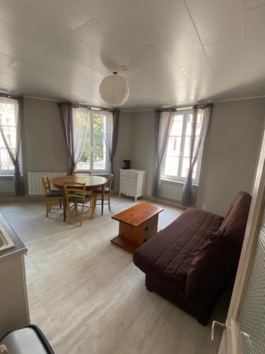 ein Wohnzimmer mit einem Sofa und einem Tisch in der Unterkunft Joli appartement entier T2 centre ville de Cherbourg in Cherbourg en Cotentin
