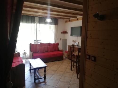 a living room with a red couch and a window at GAUDISSARD A619 in Barcelonnette