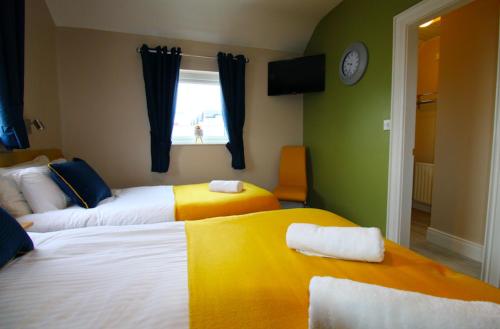 a hotel room with two beds and a window at Beulah Guest House in Portrush