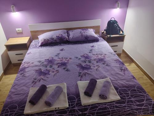 a purple bed with two pairs of socks on it at Vila Bella Mia in Timotijevići