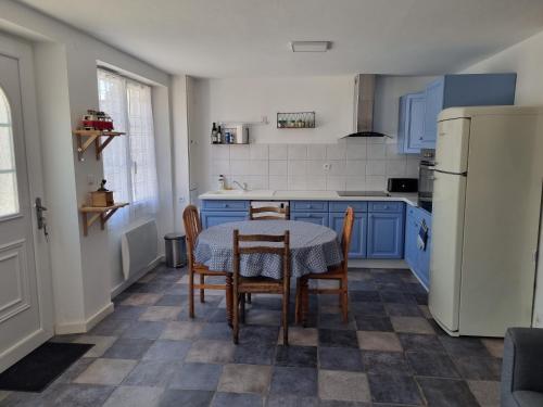 une cuisine avec des armoires bleues et une table et des chaises dans l'établissement Maison de ville Ty Richarzh, 2 chambres, 4 personnes, à Plouharnel