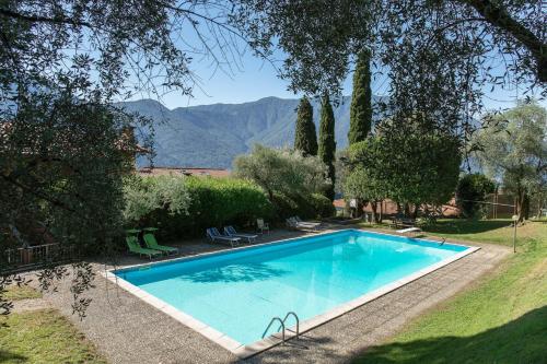 a swimming pool in a yard with mountains in the background at CASA ELLSA in Tremezzo