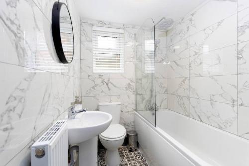 a bathroom with a sink and a toilet and a tub at Modern centrally located 3 bed property with TVs in each bedroom super fast WiFi and crisp white hotel linen hosted by Our Home Short Stays in Darlington