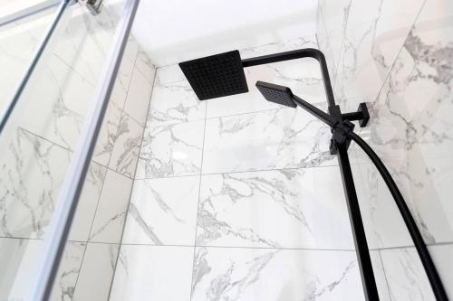 a shower with a glass door and a shower head at Modern centrally located 3 bed property with TVs in each bedroom super fast WiFi and crisp white hotel linen hosted by Our Home Short Stays in Darlington