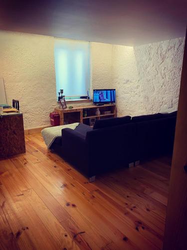 a living room with a couch and a wooden floor at Viela alojamentos Amarante in Amarante